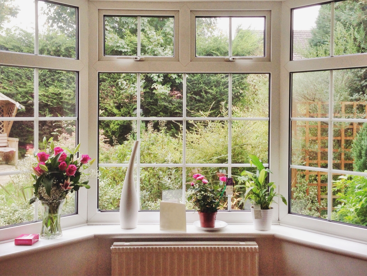 A room with many windows looking over a garden.