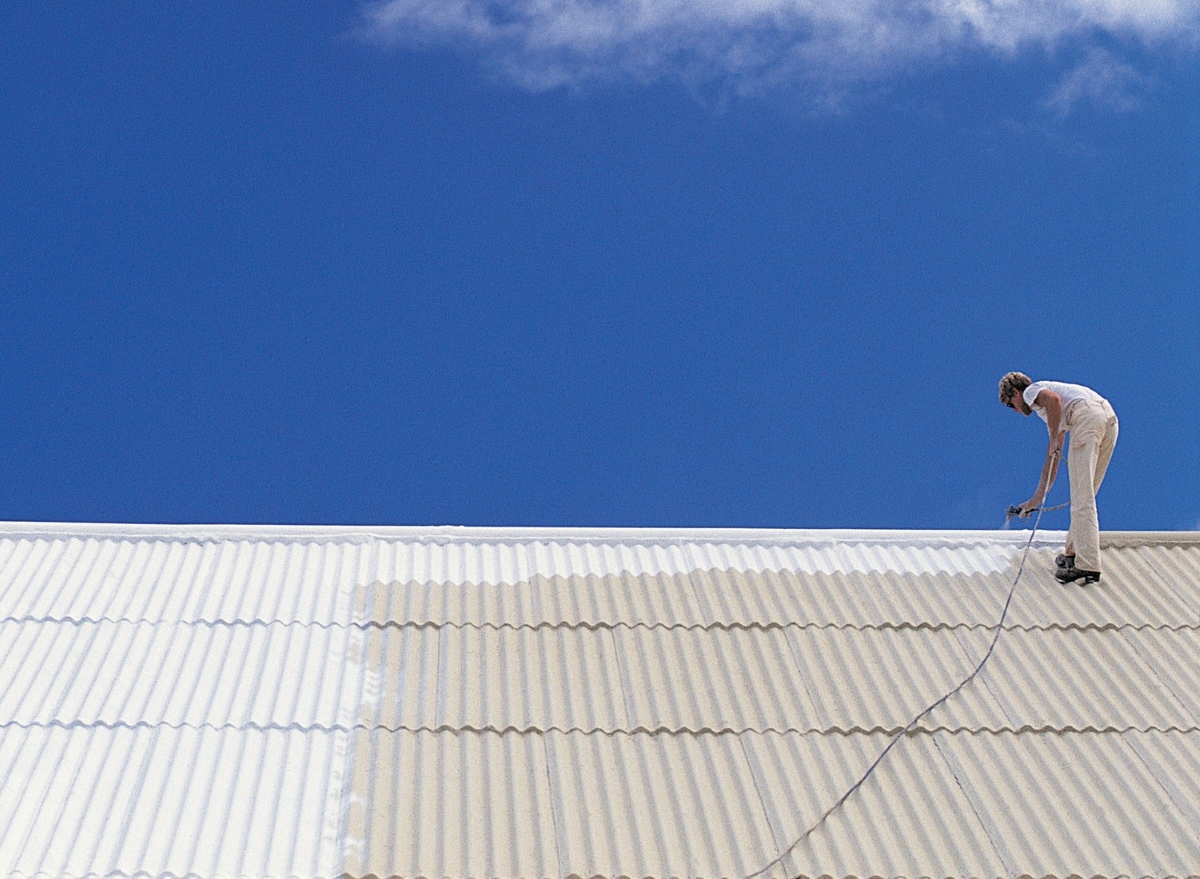 A person is painting the roof white.