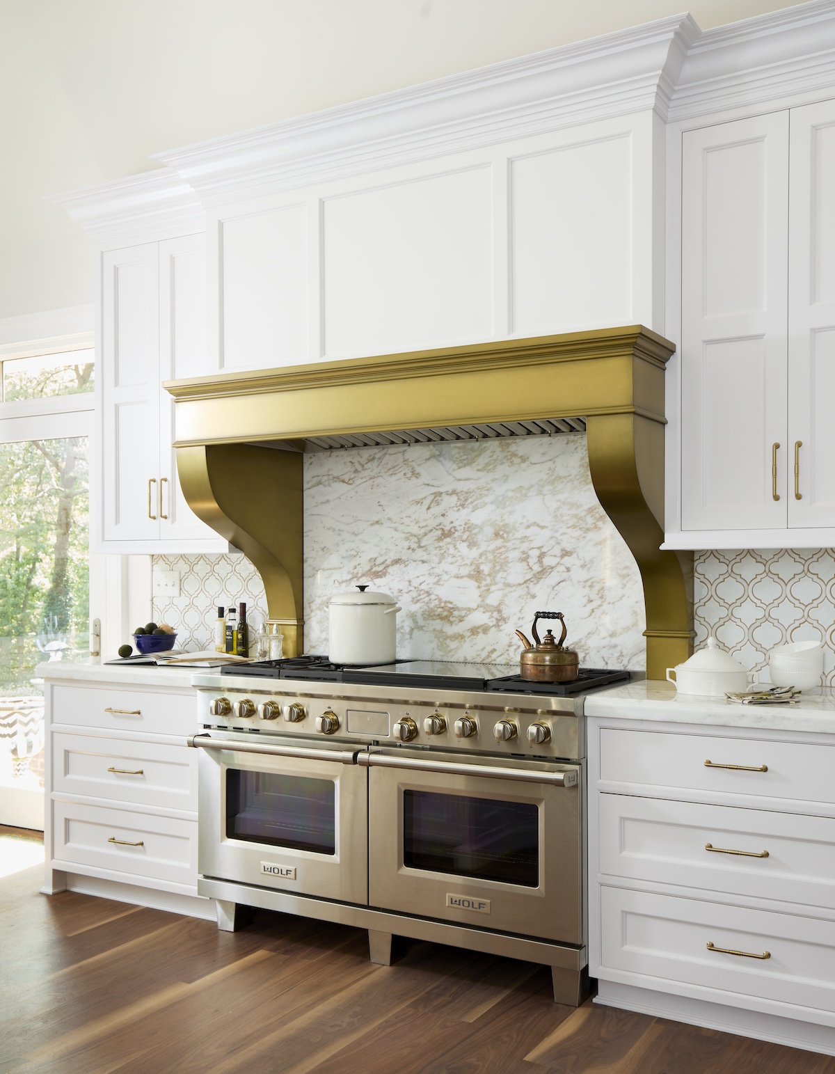 Grothouse Anvil Metal range hood installed in a white kitchen.