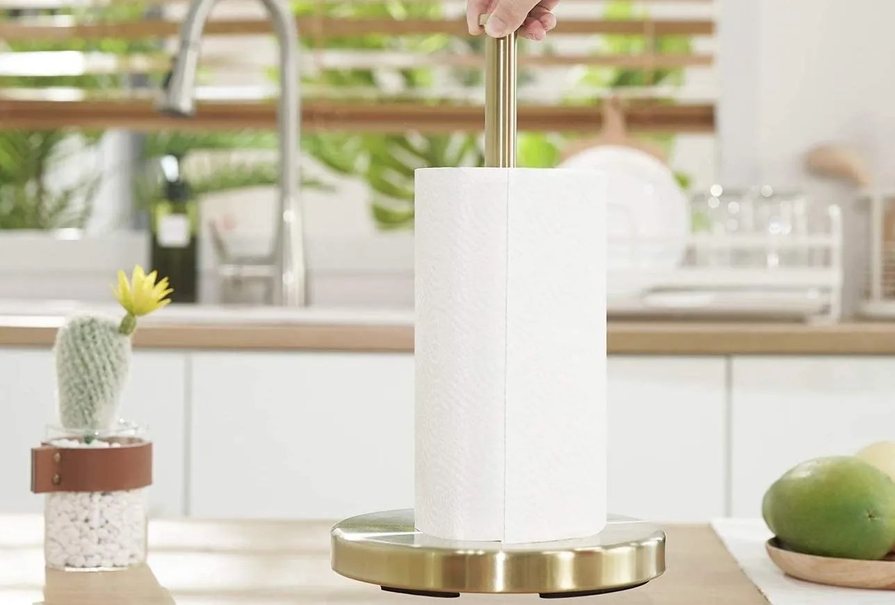KES brushed gold paper towel holder, on a kitchen counter holding paper towels.