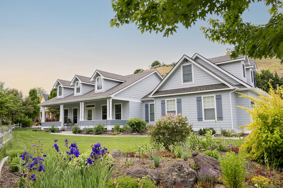 A white house with a beautiful front yard.