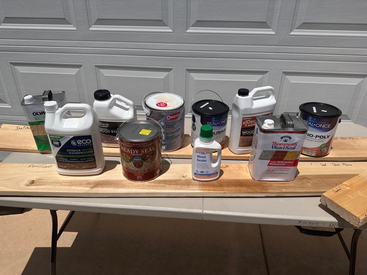 A lineup of the best outdoor wood sealers on wood boards during testing.