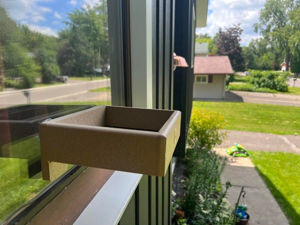 Birds Choice brown Window Bird Feeder platform attached to window of home on sunny day
