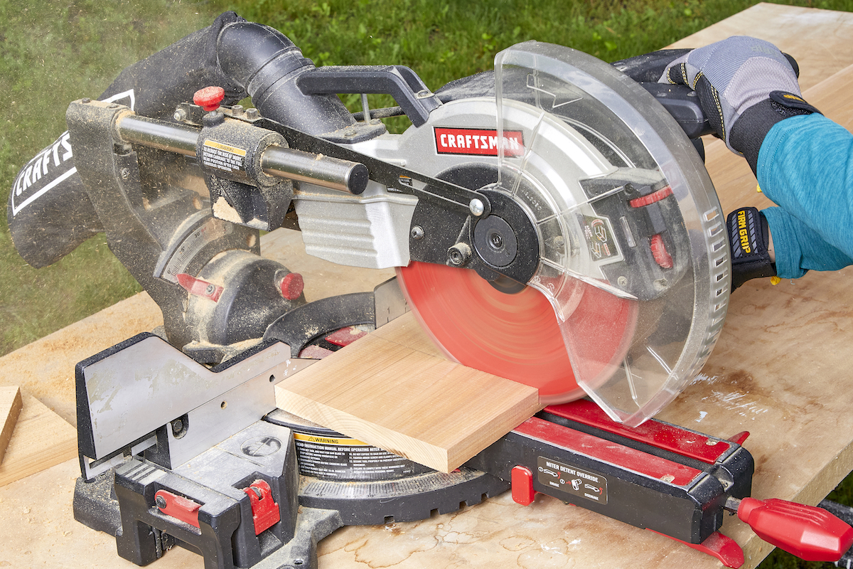 Using a miter saw to cut a piece of wood.
