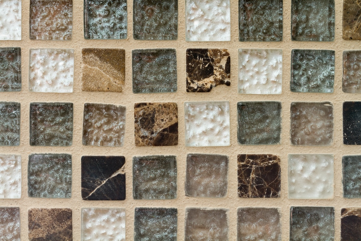 Rows of brown, white, and grey stone tiles with sanded grout.
