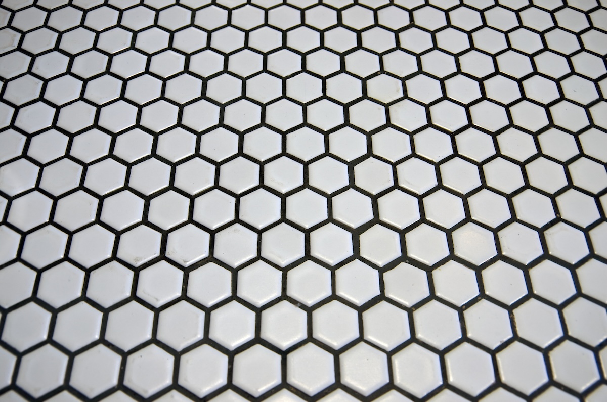 White hexagonal tiles with dark unsanded grout.