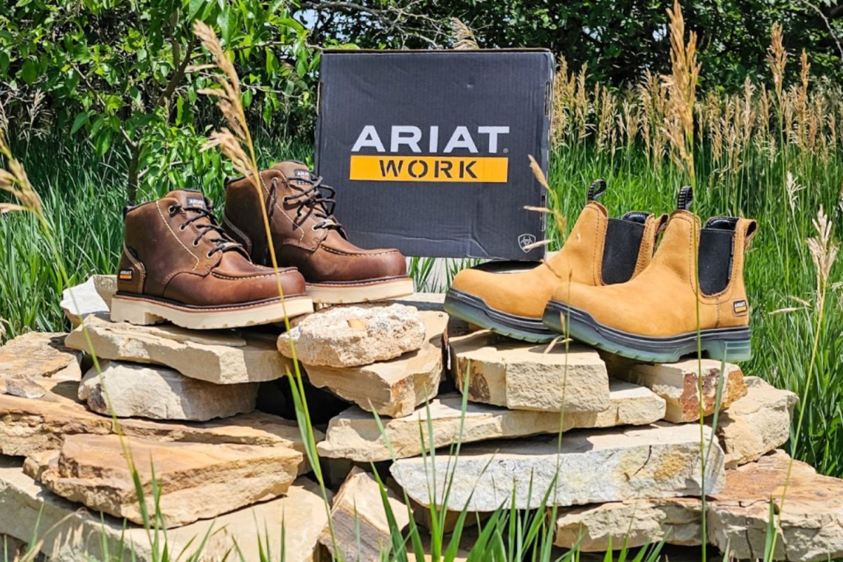 Ariat Life Rebar and Turbo Chelsea work boots sitting on flagstones outside next to Ariat box