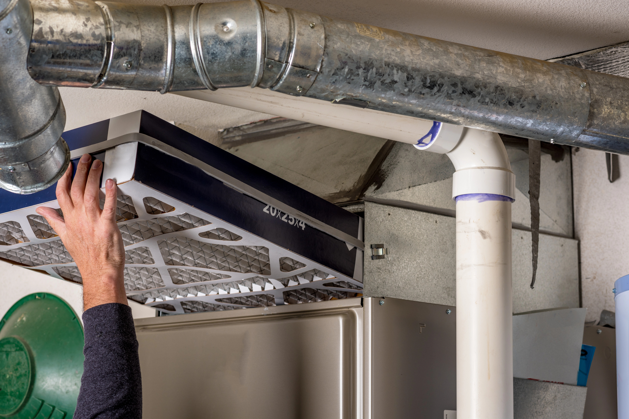 A person replaces a large filter in a furnace