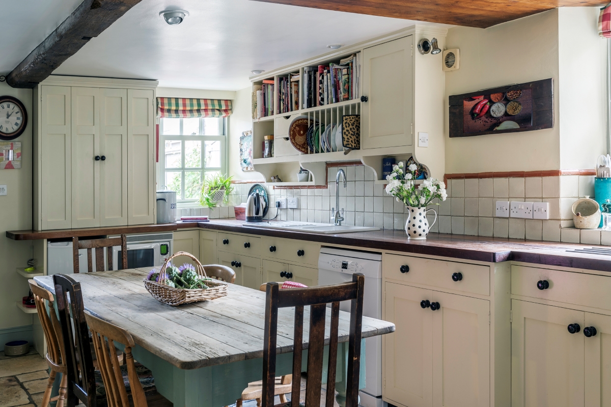 A bright, light colored, country styled kitchen.