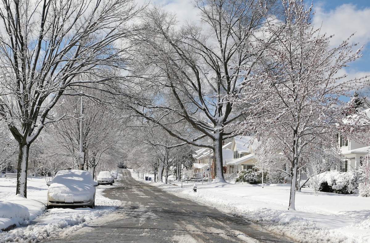 A suburban neighborhood after a light snow storm.