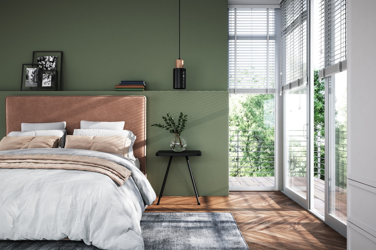 A modern bedroom with green painted walls.