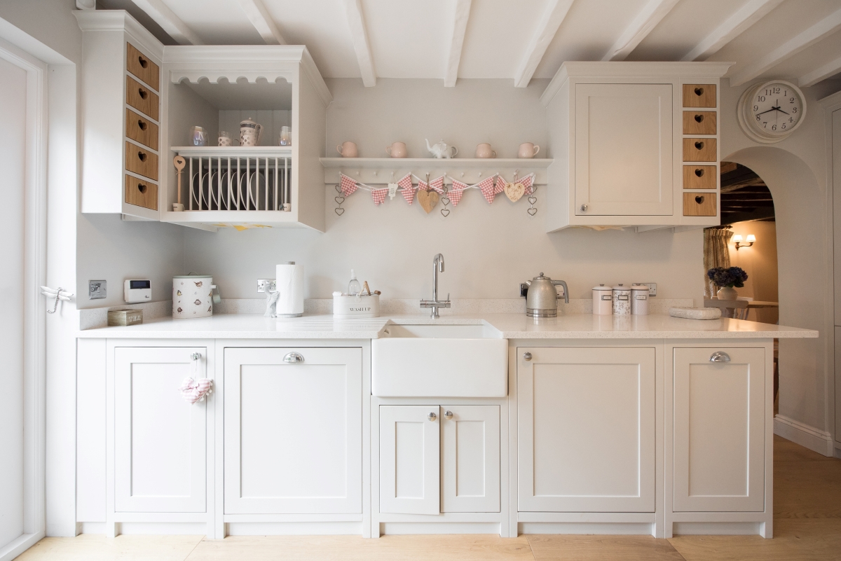 A bright white kitchen with light grey cabinets.