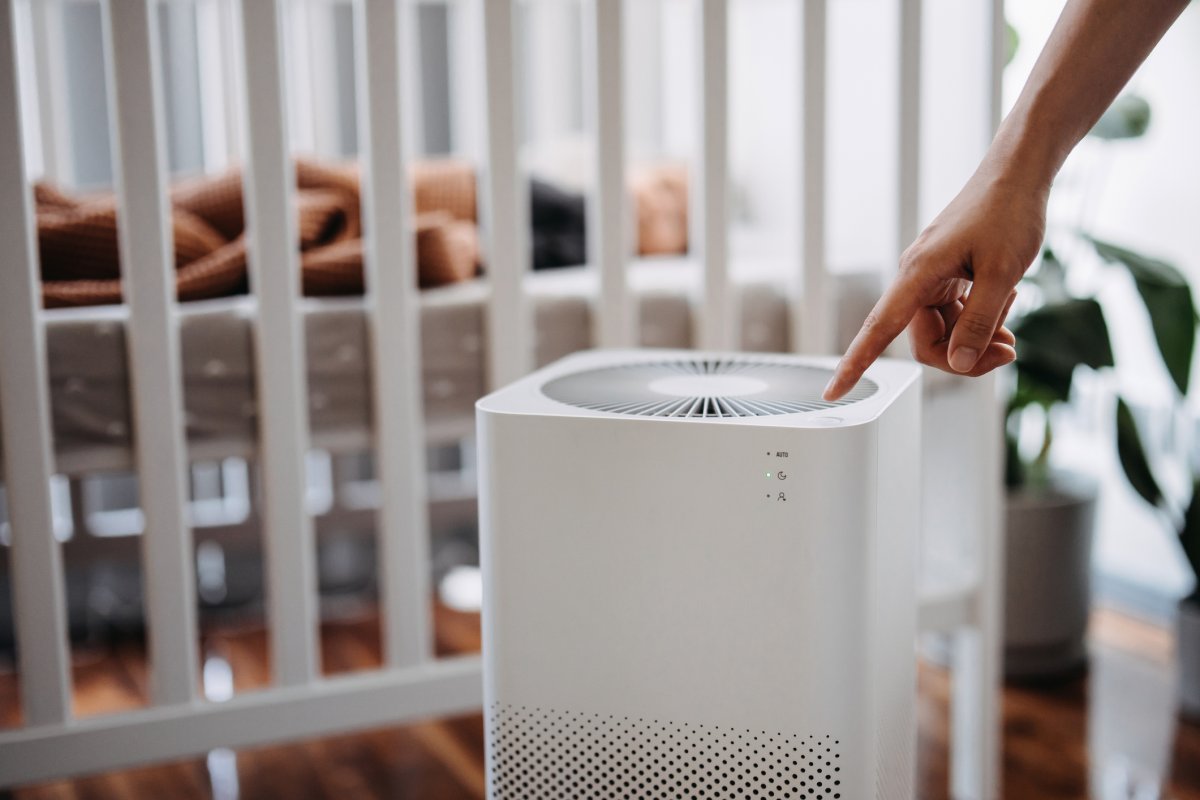 Close up hand of a woman turning on home air purifier.