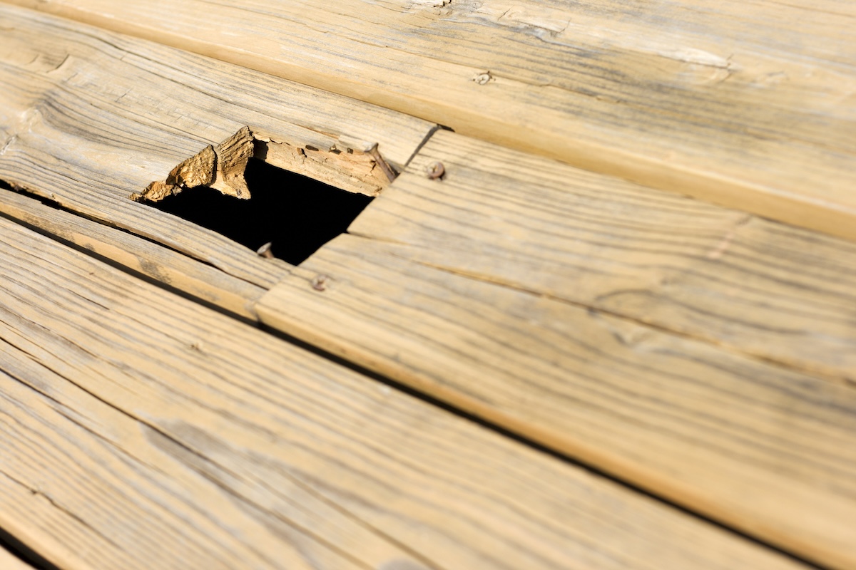 A damaged deck board in need of replacement.