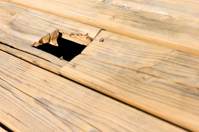 A damaged deck board in need of replacement.