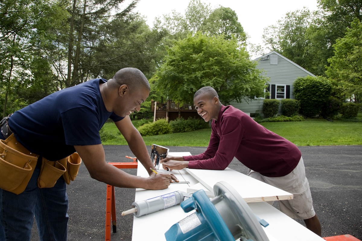 Father and son working on a home improvement project in the backyard.