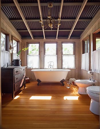 A view of a bathroom with wood flooring. 