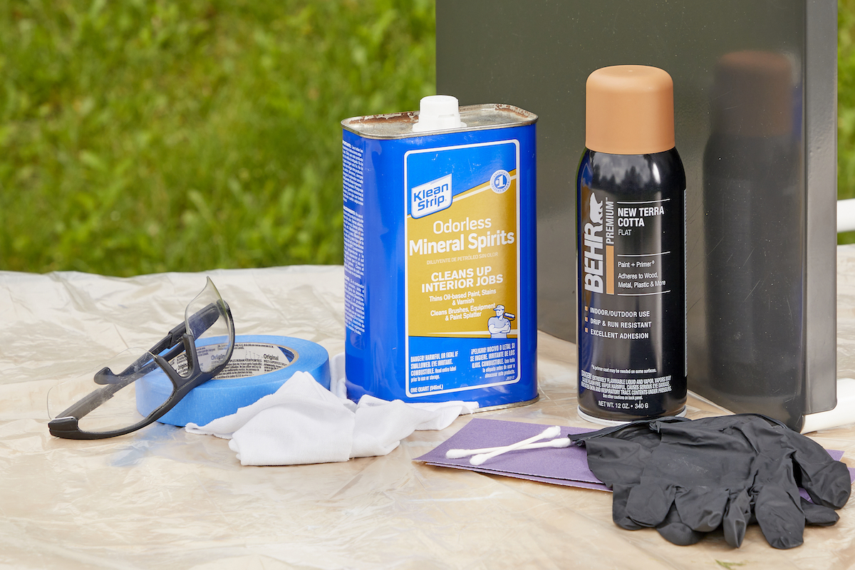 Materials needed for spray painting metal, including paint, paint thinner, and eye protection.