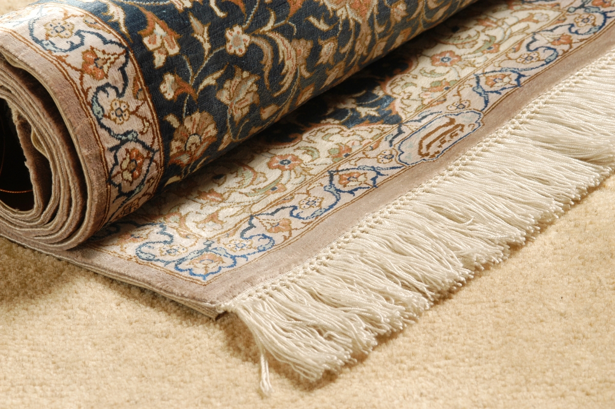 A rolled rug on beige carpet.