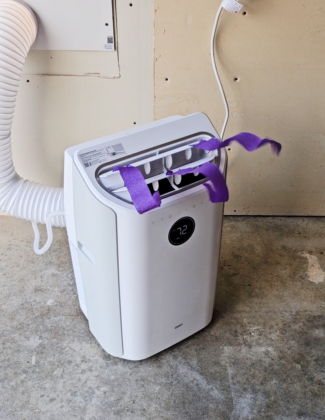 White Dreo portable air conditioner on concrete garage floor