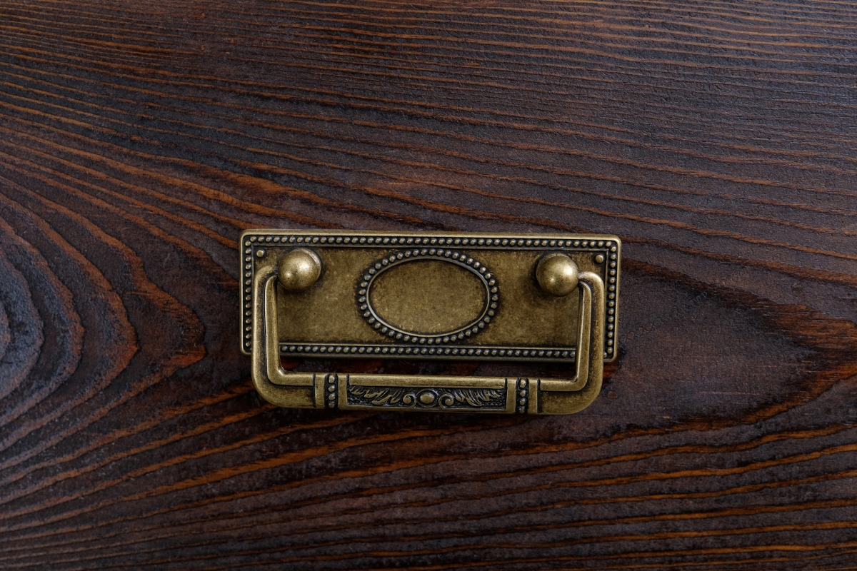 A vintage iron handle on wooden drawer.