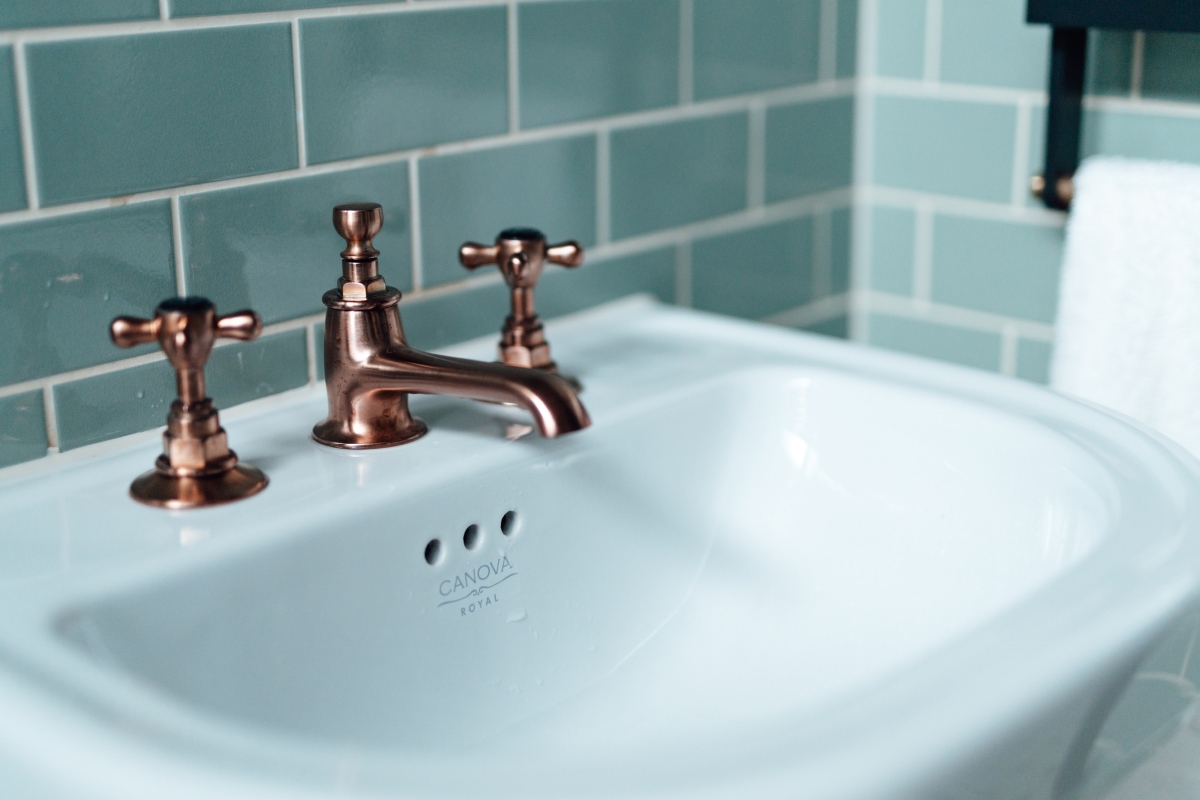 A vintage sink and copper faucet.