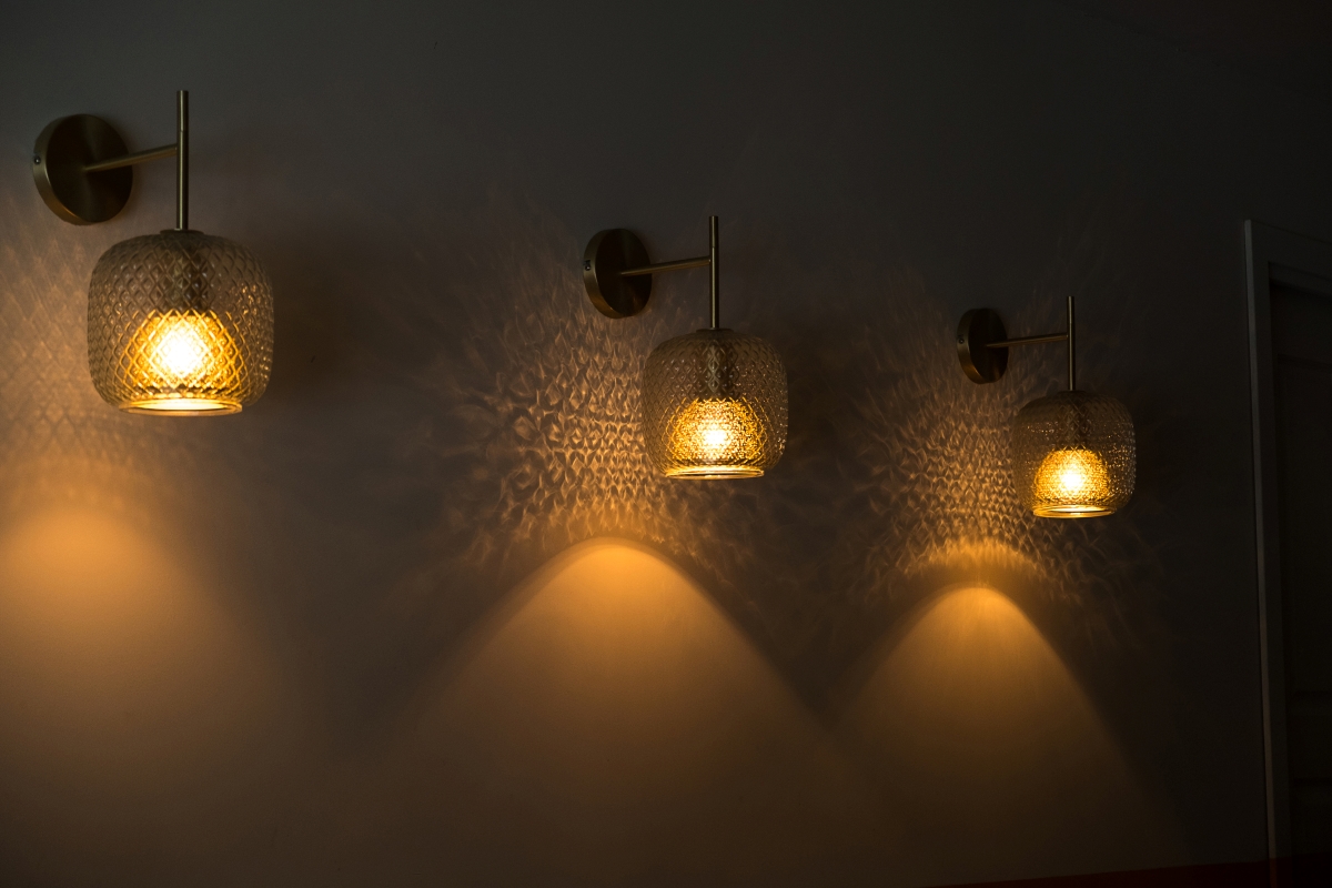 Multiple walls sconces lit in the dark.