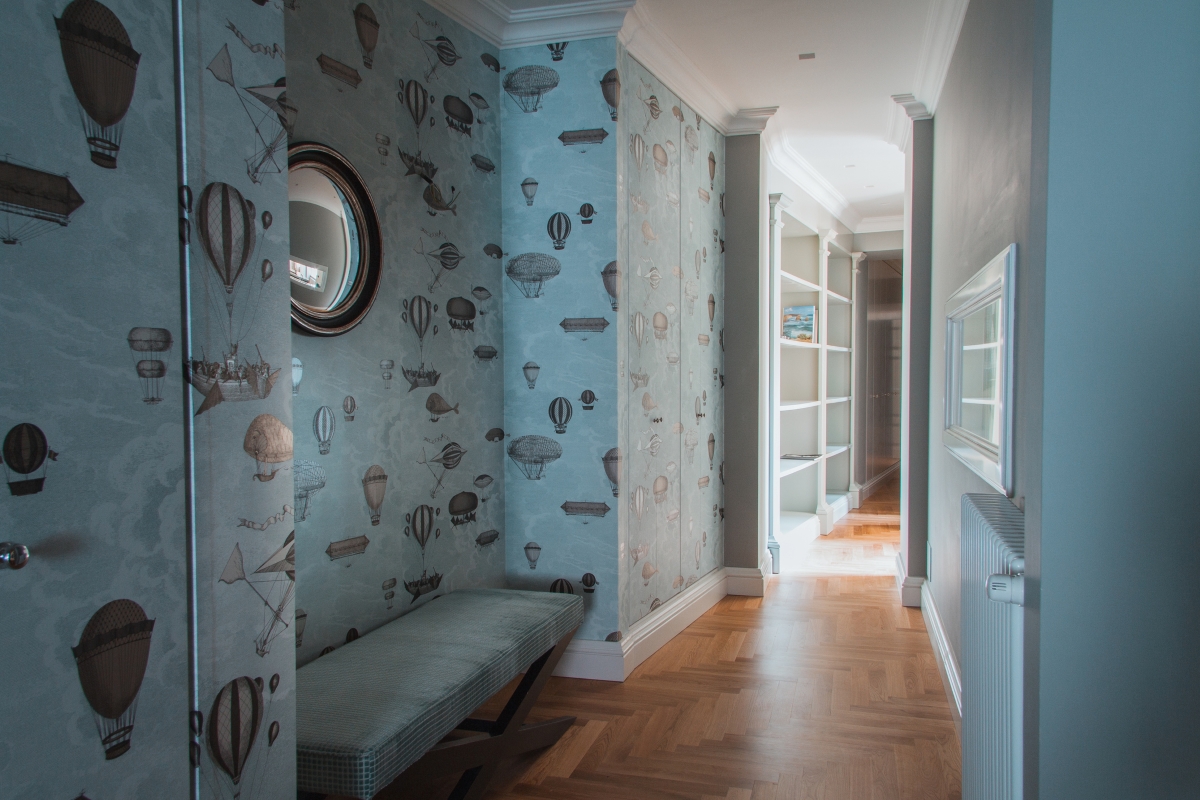 A corridor decorated with a blue hot balloon wallpaper.