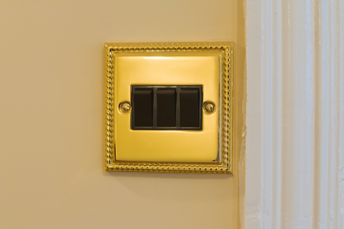 An antique brass light switch cover.