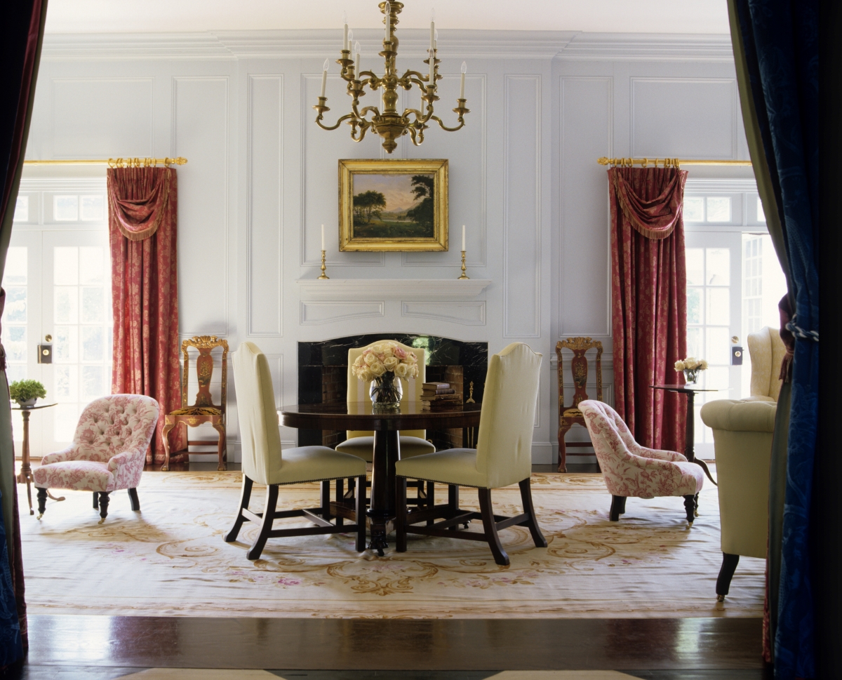 A formal living room with antique furniture and chandelier.