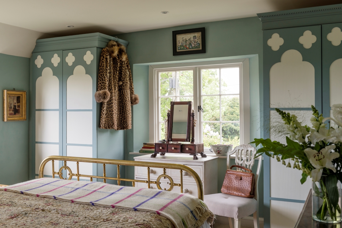 A bedroom with decorative built-in shelving closets.