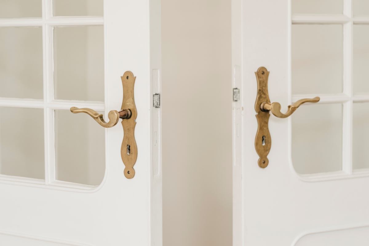 Two opened doors with antique door handles.