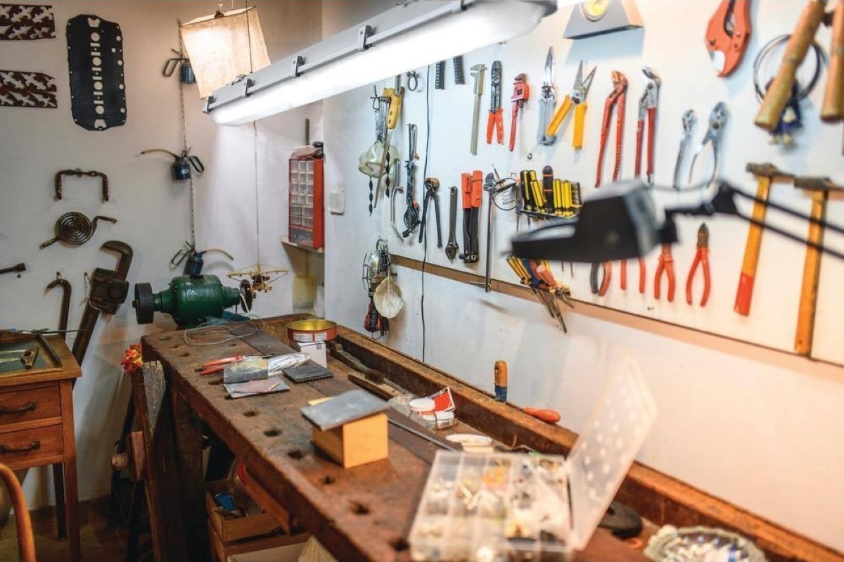 Various tools are hung on a pegboard next to a work table.