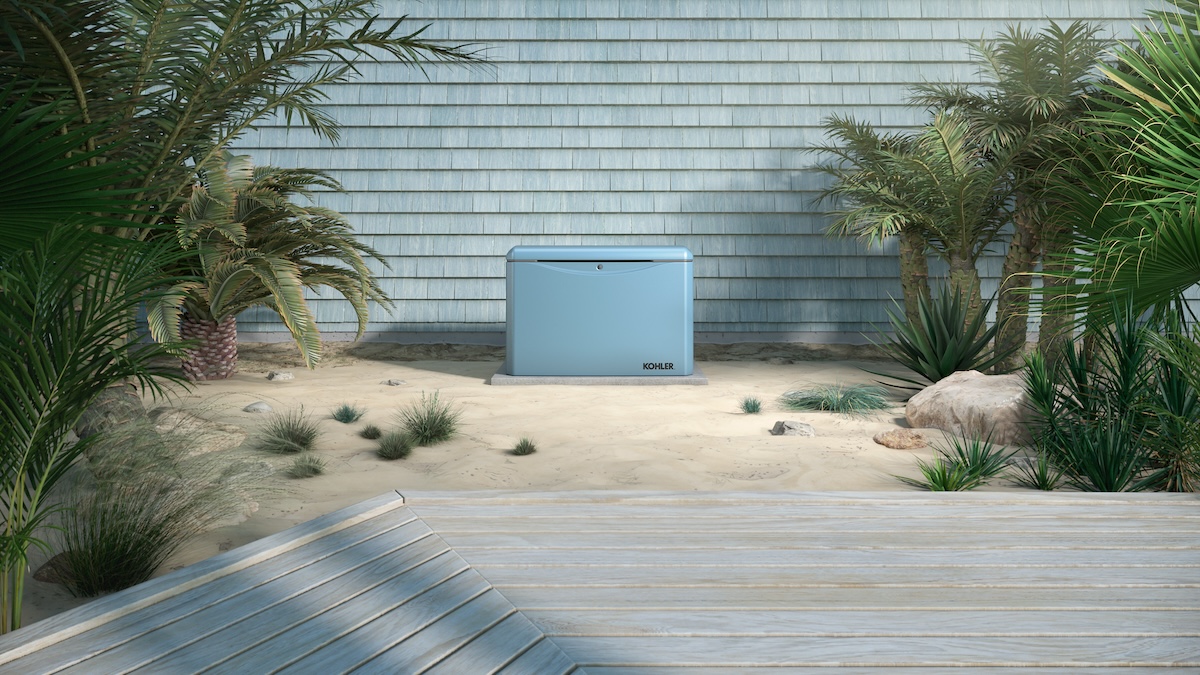 A blue Kohler home generator installed near a coastal home.