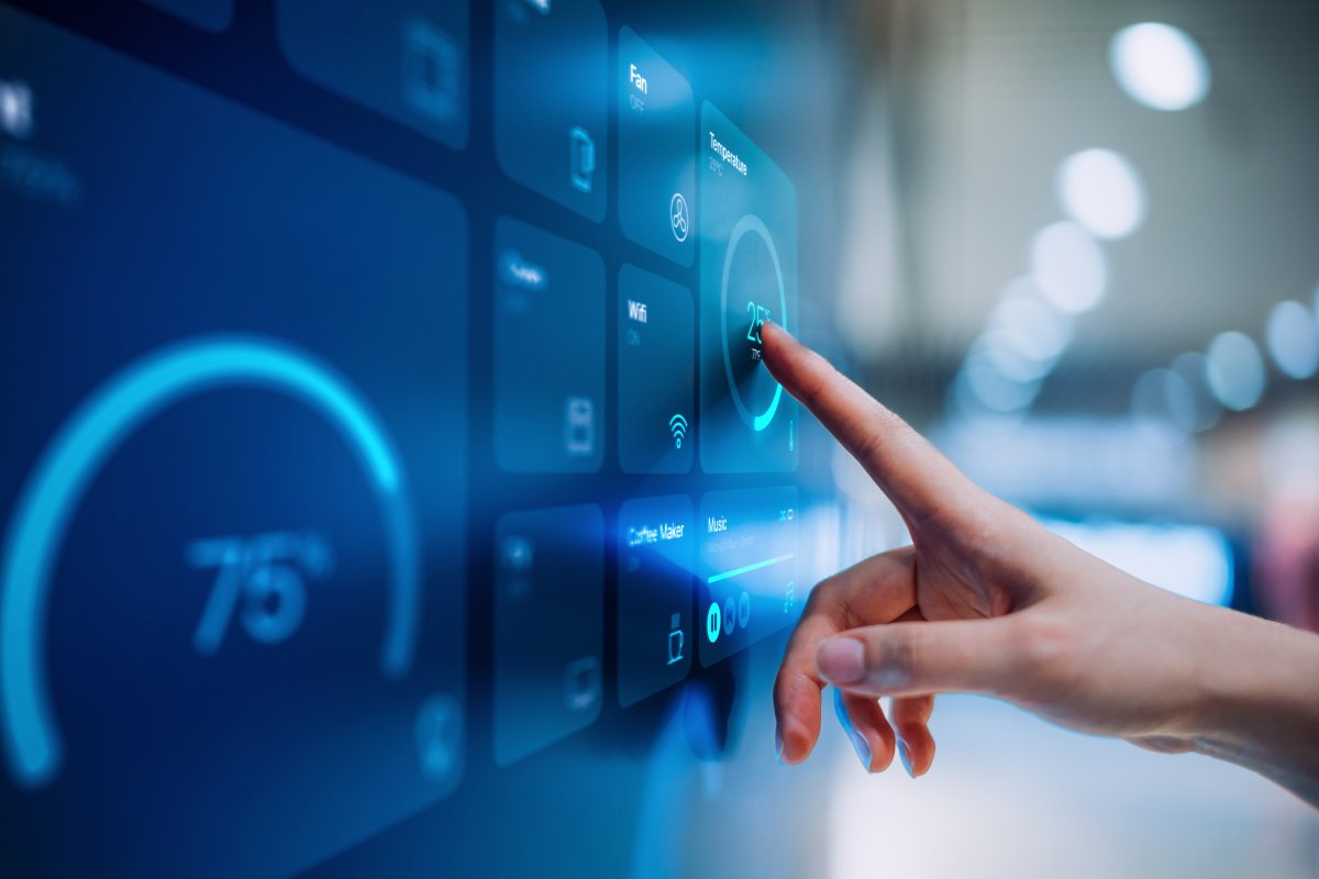 Close up of woman's hand setting up intelligent home system, controlling smart home appliances with control panel of a smart home.