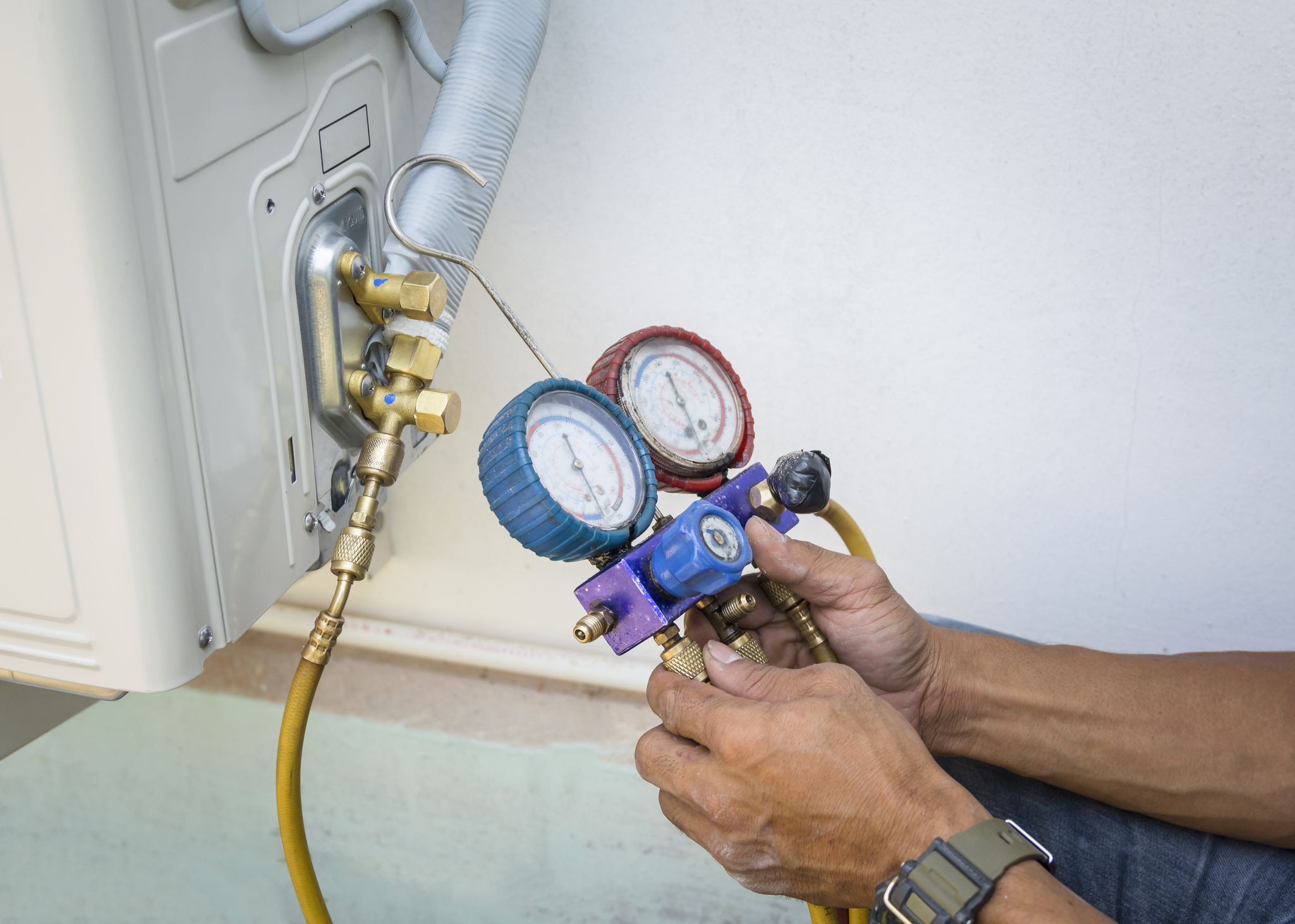 An HVAC technician uses a manometer to check to check the air pressure of heat pump system.