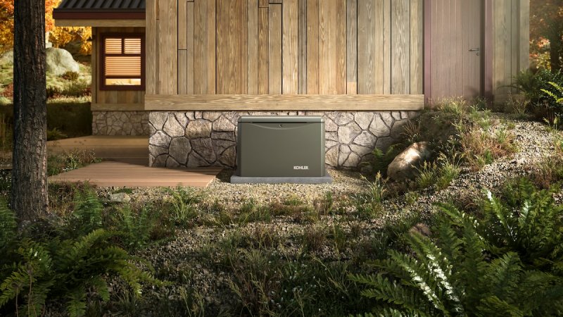 A green Kohler home generator installed outside of a home.