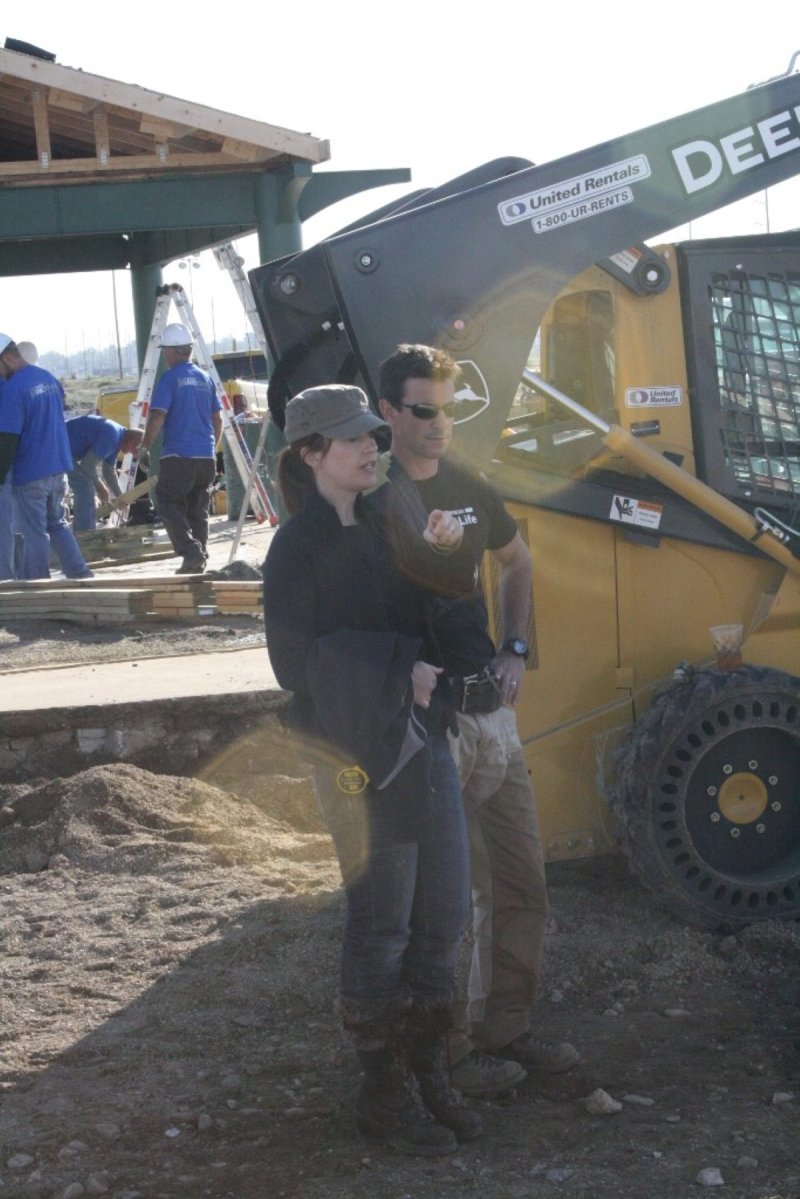 Two people overseeing a project near large construction equipment.