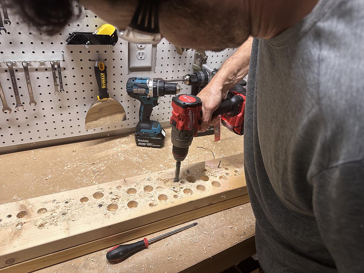 Person using the Milwaukee M18 Hammer Drill to bore holes into lumber