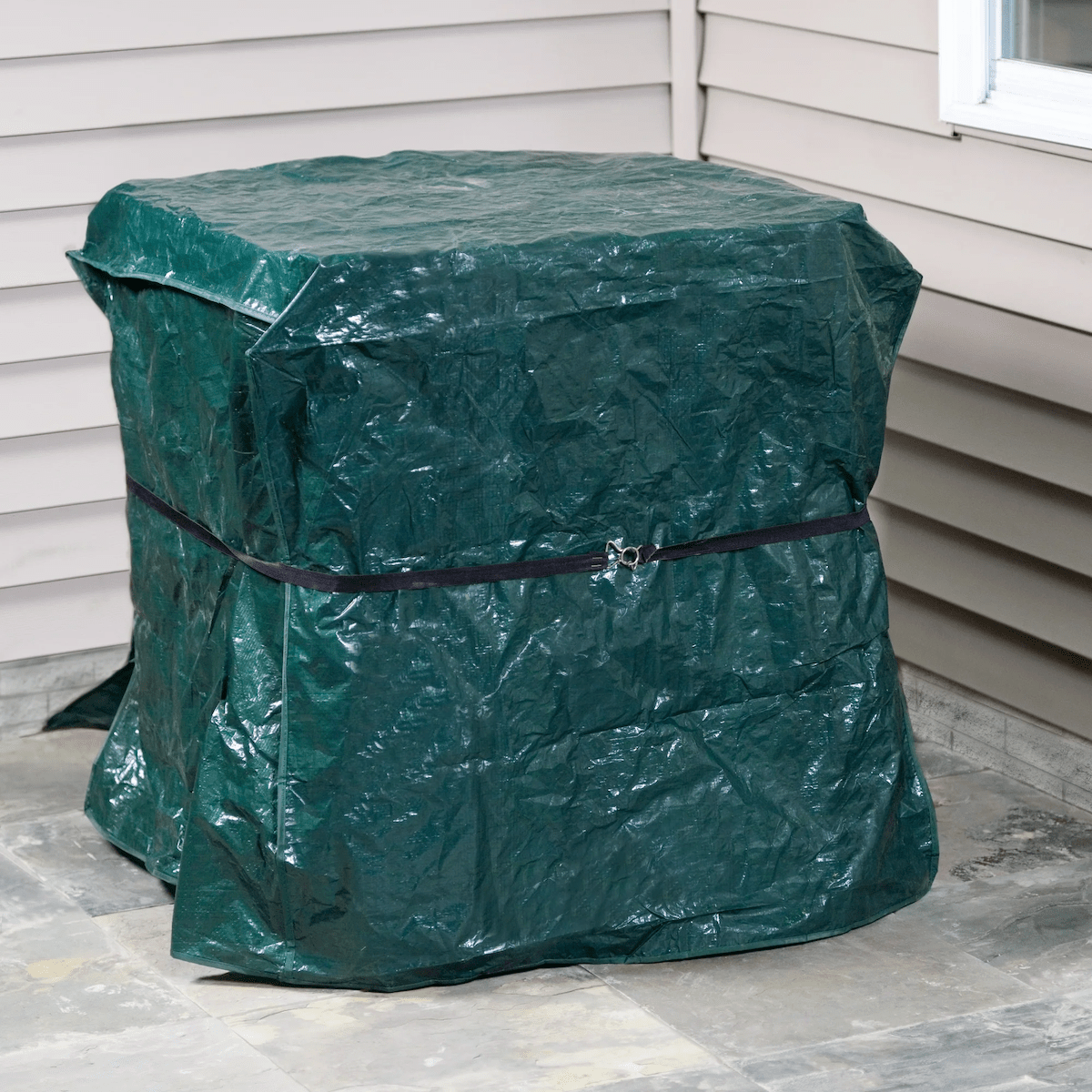 A tarp covering an outdoor air conditioner condenser unit.