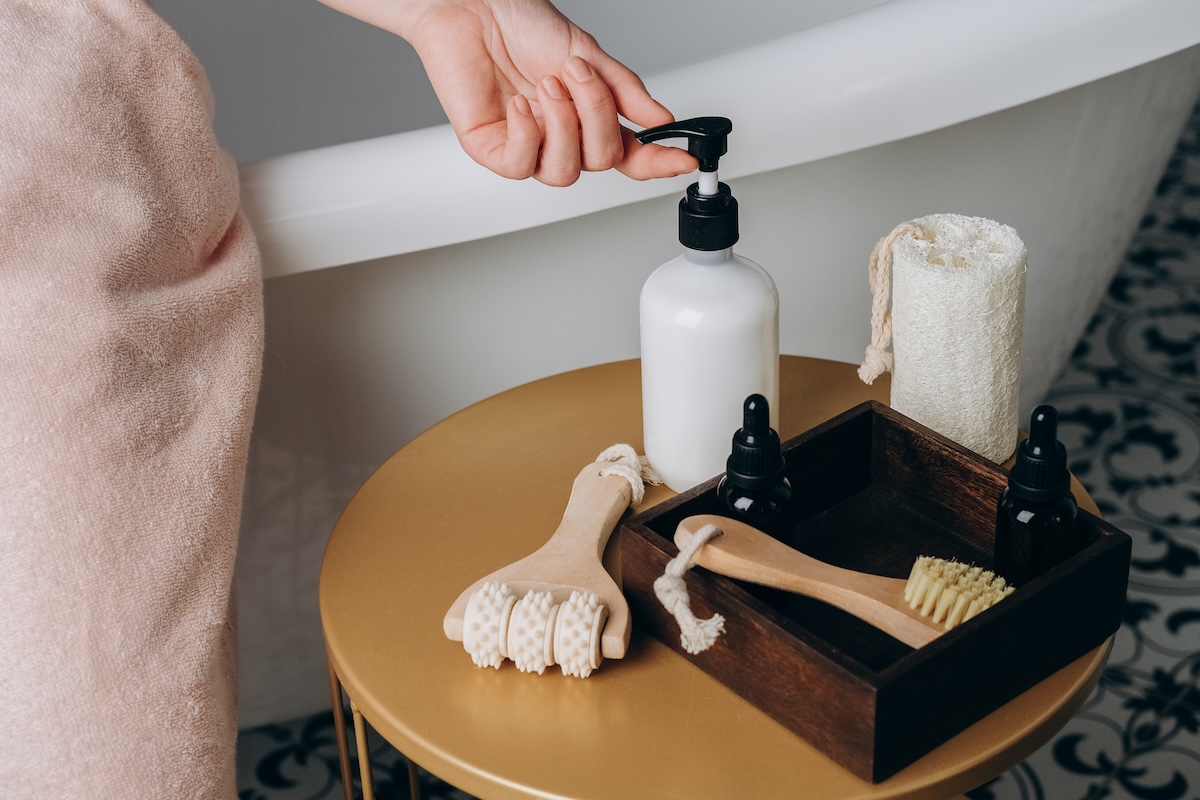 A small stool in the bathroom with lotion an other toiletries.