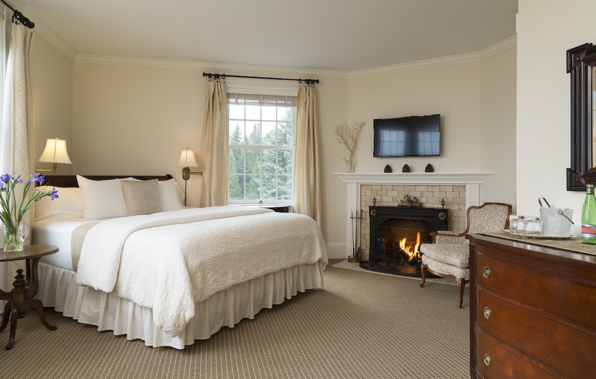 A grey and beige bedroom with a fireplace.