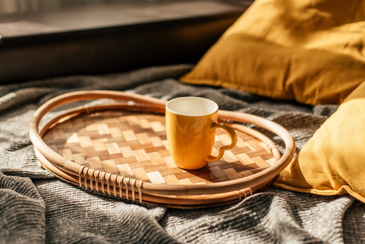 A wooden coffee tray sitting on a bed.