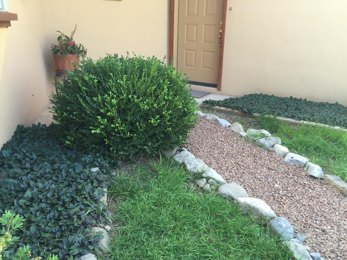 A hardscaping gravel pathway leading to a house.