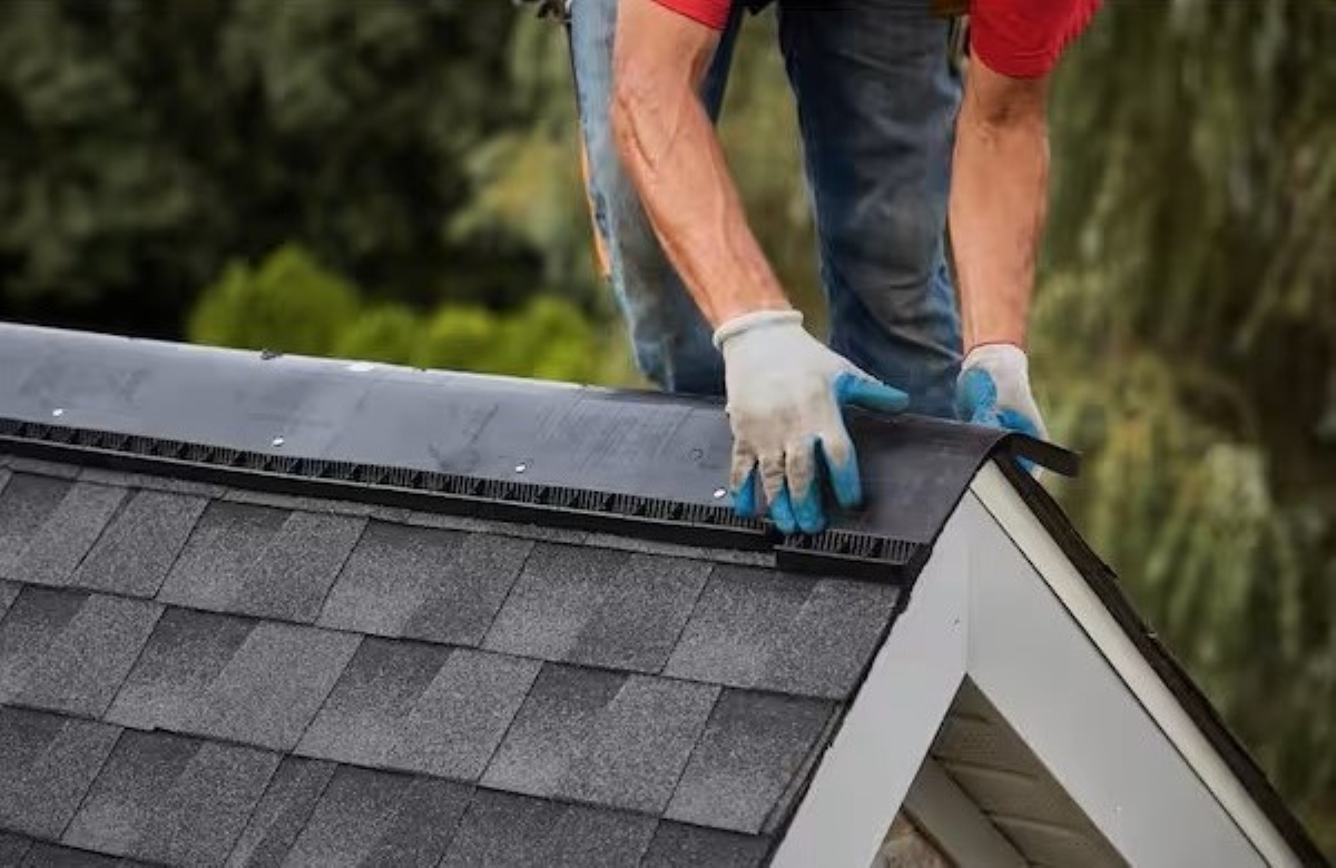 Person on top of the roof adding a ridge.