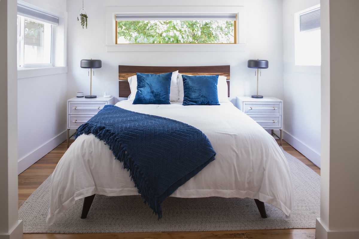 A small airy bedroom with bright windows.