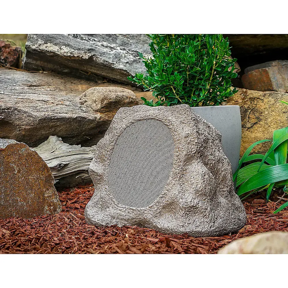 A stone shaped outdoor speaker for adding music to a garden.