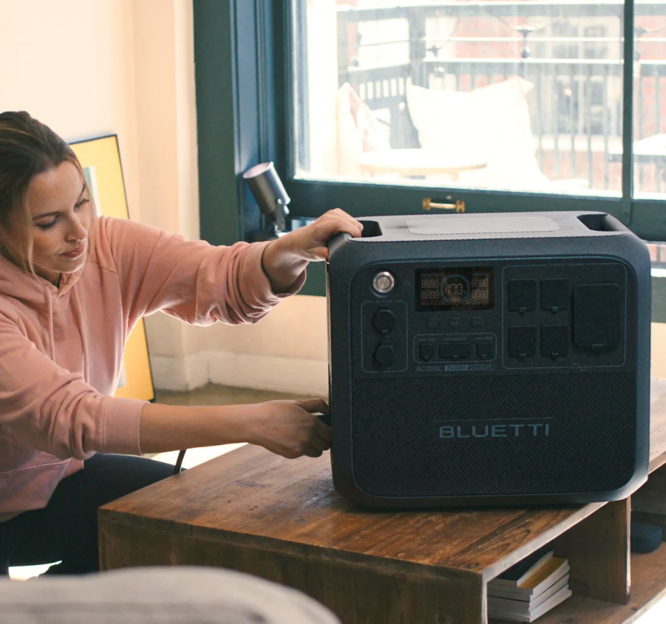 Woman setting up Bluetti AC200L as a backup power source in the home