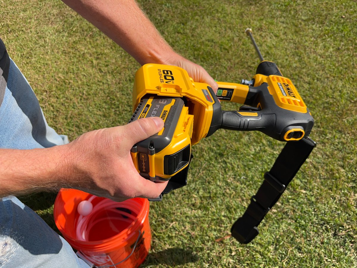 A man loads a 60-volt battery into the DeWalt Flexvolt Power Cleaner