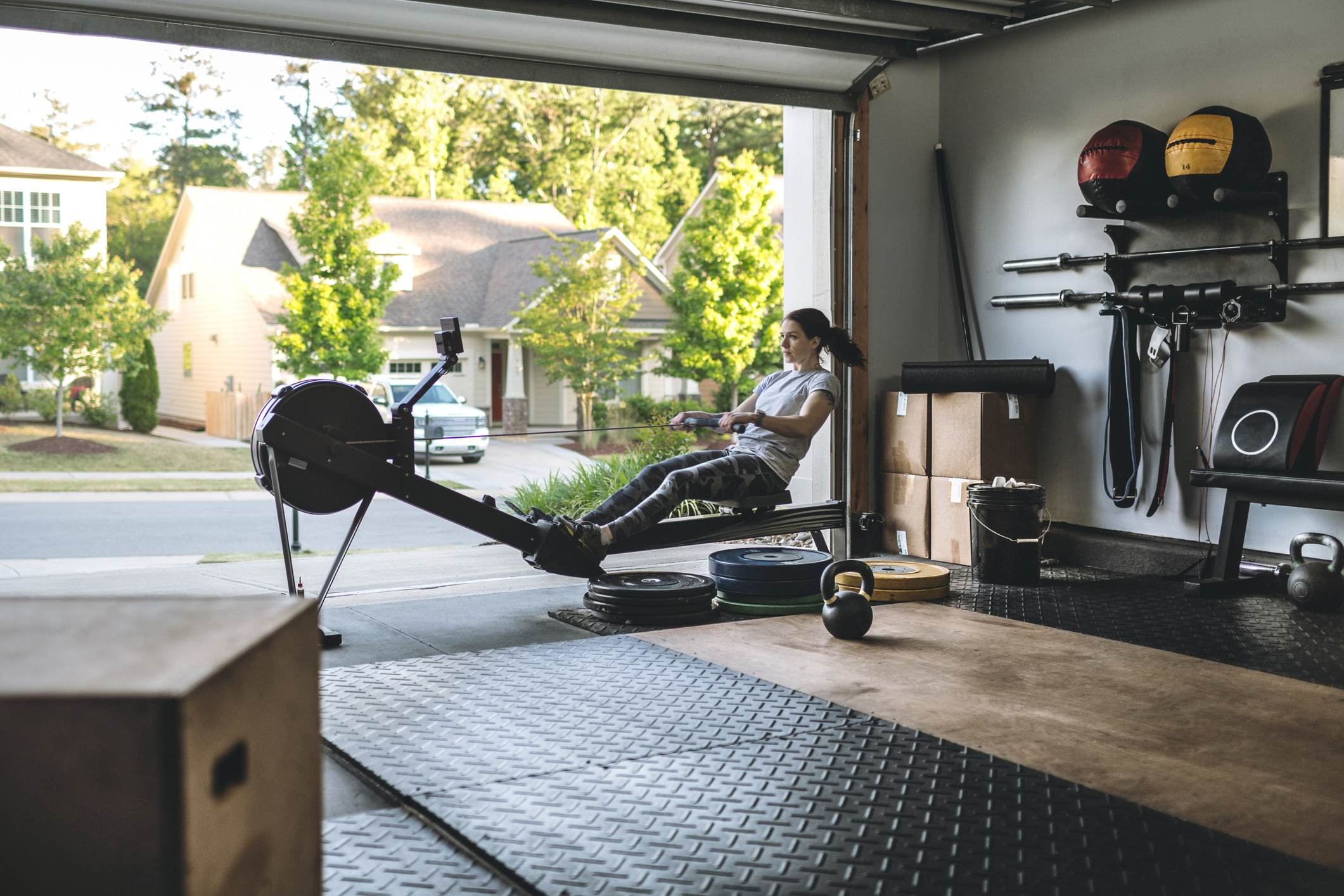 Woman exercising on a rowing machine in her home garage gym.